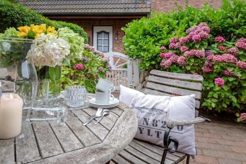 a table and chairs with flowers on a patio at Moledyk in Westerland (Sylt)