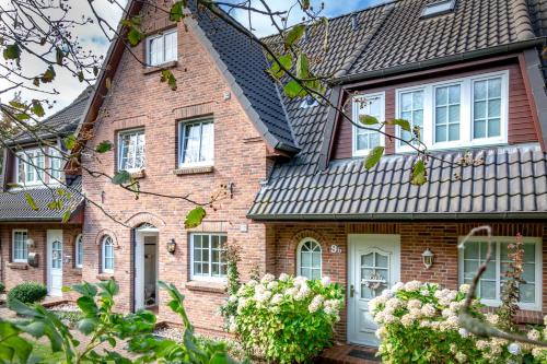 a brick house with white doors and windows at Moledyk in Westerland (Sylt)