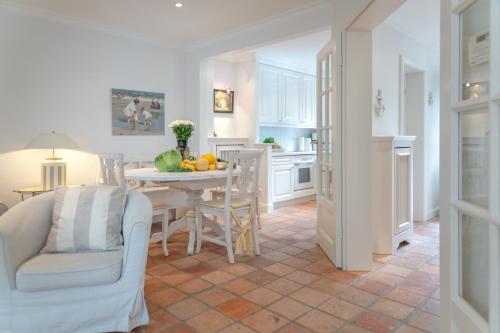 a kitchen and dining room with a table and chairs at Moledyk in Westerland (Sylt)