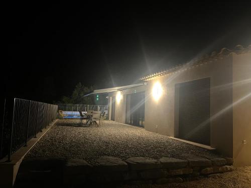 a house with a table and a fence at night at villa'nduzienne in Anduze