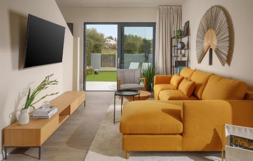 a living room with a yellow couch and a tv at Nice Home In Porec With Wifi in Poreč