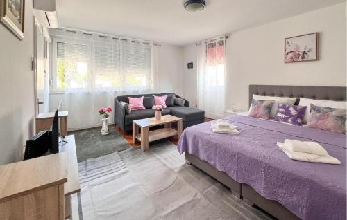 een slaapkamer met een paars bed en een bank bij Nice Apartment In Pula With Wifi in Pula