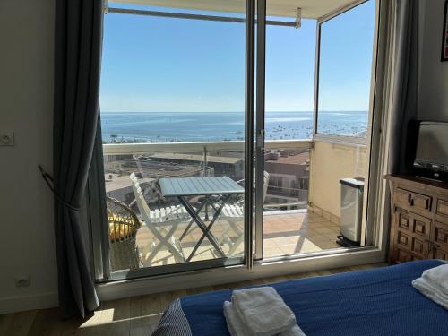 une chambre avec un lit et une grande fenêtre dans l'établissement Studio vue mer-port Arcachon, à Arcachon