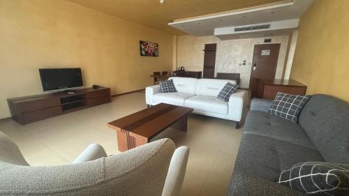 a living room with two couches and a tv at Garden of Eden Complex in Sveti Vlas