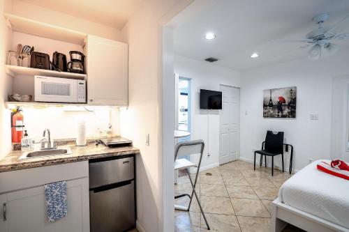 a kitchen with a sink and a room with a bed at B efficiency Off Las Olas on water free kayaks in Fort Lauderdale