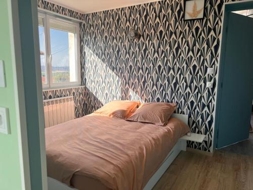 a bed in a bedroom with a patterned wall at MonacellA in Nonette
