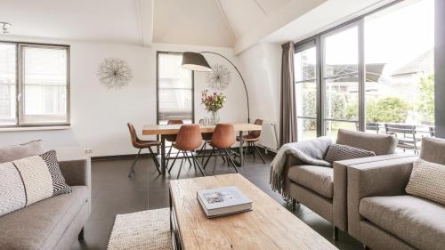 a living room with a couch and a table at OUD Duynvallei in Schoorl
