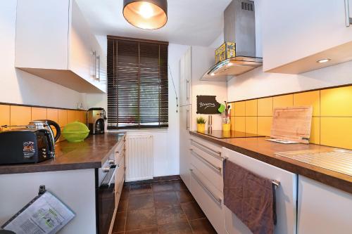 a kitchen with yellow and white walls and counters at Appartement Côté Vignes avec Terrasse et Parking in Kientzheim