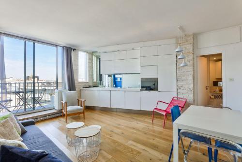 une cuisine et un salon avec une grande fenêtre dans l'établissement GuestReady - Charmant Séjour avec Vue Panoramique, à Paris