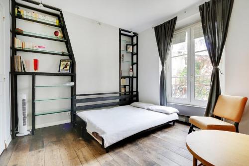 une chambre avec un lit et une étagère dans l'établissement GuestReady - Studio Idéal pour 2 au cœur de Paris, à Paris