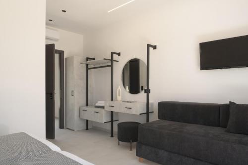 a bedroom with a couch and a sink and a mirror at Elia Villa, with Pool, SeaViews & Iconic Design, By ThinkVilla in Astérion