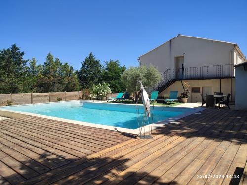 une piscine sur une terrasse à côté d'une maison dans l'établissement La maison des amis, à Lussan