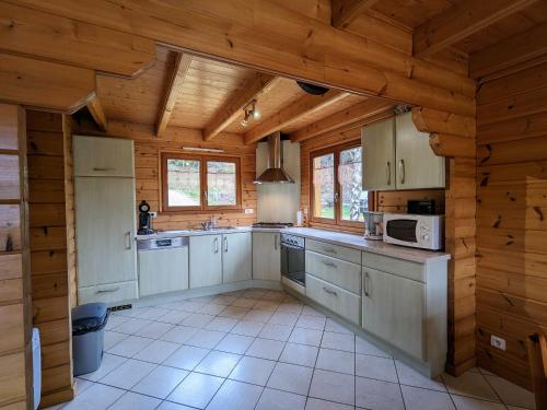 Il comprend une grande cuisine avec des murs et des plafonds en bois. dans l'établissement Chalet chaleureux avec terrasse, proche forêt et sentier, à 15 km des stations de ski de Gérardmer - FR-1-589-247, à Vagney