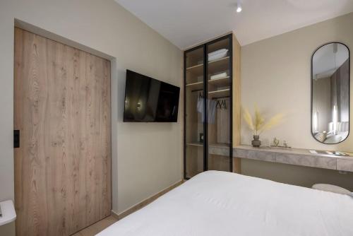 a bedroom with a large bed and a mirror at Aristotelian Virtues - Elpida in Thessaloniki