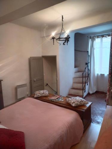 ein Schlafzimmer mit großem Bett und Treppe in der Unterkunft Coquette petite maison de village in Aups