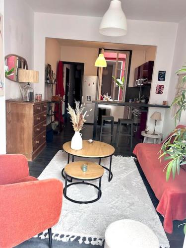 un salon avec un canapé rouge et une table dans l'établissement Appartement Cosy, à Bordeaux