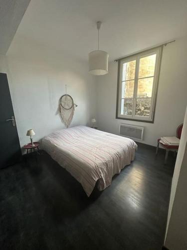 une chambre avec un lit et une grande fenêtre dans l'établissement Appartement Cosy, à Bordeaux