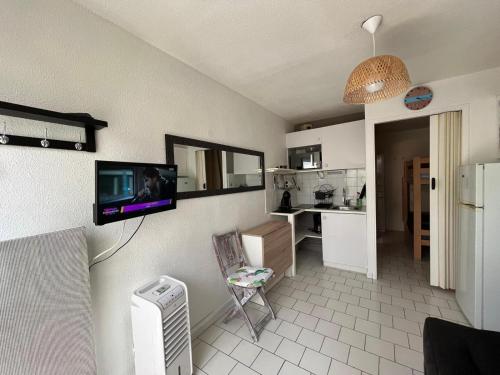 une cuisine avec une télévision au mur dans l'établissement A la grande conque, au Cap d'Agde