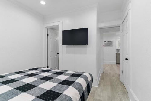 Un dormitorio con una cama y un televisor de pantalla plana. en Chic 1br Orlando Rental Kitchen & Fast Wi-fi, en Orlando