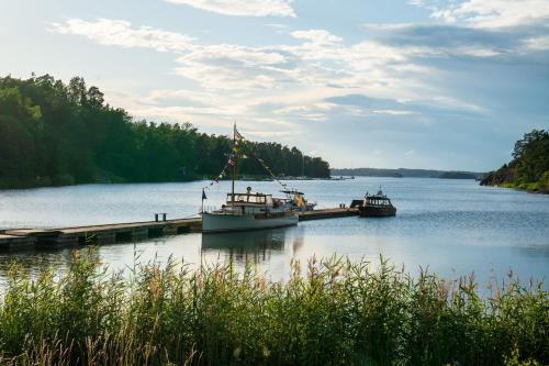 two boats are docked at a dock on a lake at Skeviks Gård in Gustavsberg