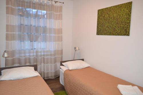 プルンゲにあるNG Apartmentsのベッド2台と窓のある寝室