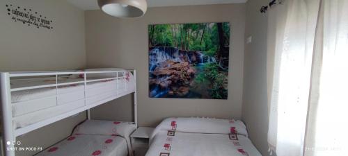 a bedroom with two bunk beds and a painting on the wall at Mi Descanso in El Bosque