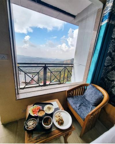 Amor Haven & Dine في شيملا: طاولة مع طبقين من الطعام ونافذة