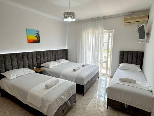a bedroom with two beds and a tv at Apartments Ela in Ulcinj
