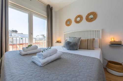 een slaapkamer met twee bedden en een groot raam bij Central but quiet, pool and WIFI - fibre in Tarifa