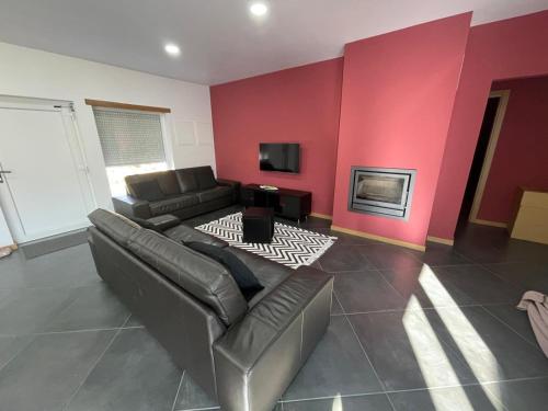 a living room with a couch and a red wall at LMB Alojamento local in Penacova