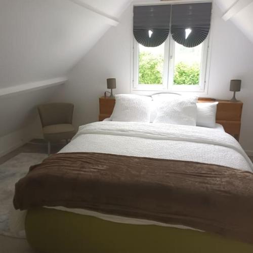 une chambre avec un grand lit et une fenêtre dans l'établissement la maison au bord de l'eau, à Liancourt-Saint-Pierre