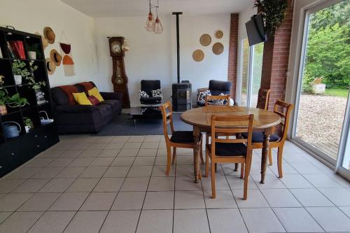 un salon avec une table et des chaises dans l'établissement la maison au bord de l'eau, à Liancourt-Saint-Pierre