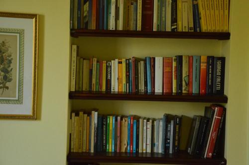 a book shelf filled with lots of books at Agriturismo Picchio Rosso in Forlì