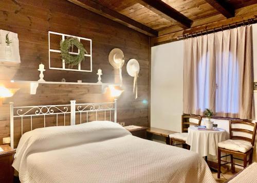 a bedroom with a white bed and a table and chairs at country house in Ardea