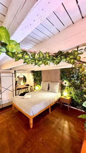 - une chambre dotée d'un lit avec des plantes sur le mur dans l'établissement Jungle Love Room avec Jaccuzi au coeur de Nice, à Nice