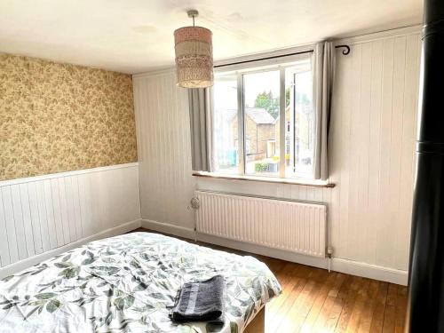 Ένα ή περισσότερα κρεβάτια σε δωμάτιο στο Inviting 4-Bed House near Heathrow w Fireplace