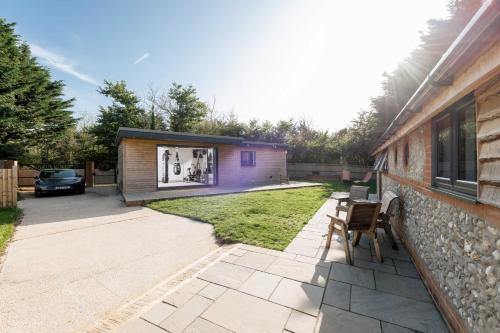 a backyard with a house with a table and chairs at Hillview Hideaway in Angmering