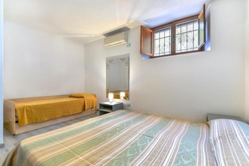 Un dormitorio con dos camas y una ventana. en Villa Mirella Bilocale, en Capoliveri