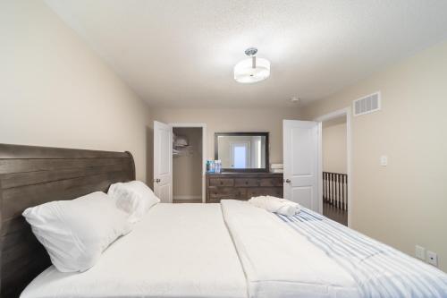 a bedroom with a large bed with white sheets and pillows at Beautiful New Townhouse in Quiet Neighbourhood in Ajax