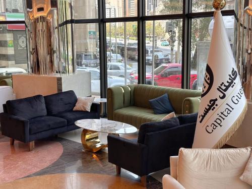 una stanza con divani e un cartello in un negozio di فندق كابيتال جيست Capital Guest hotel a La Mecca