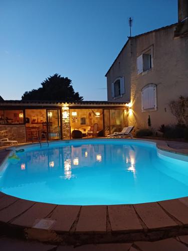 une grande piscine bleue devant un immeuble dans l'établissement Villa aux pieds des alpilles, à Eygalières