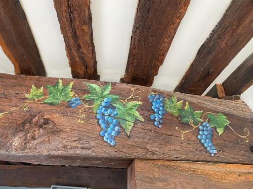une grappe de raisin bleu sur une poutre en bois dans l'établissement Au pichet de Bourgogne, à Auxerre