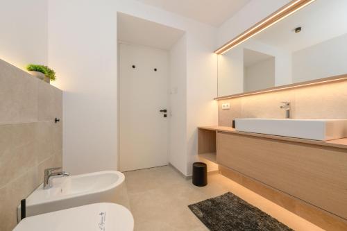 a bathroom with a sink and a toilet and a mirror at MGH Luxury - Corte Garden Bardolino 34 in Bardolino