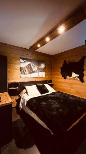 - une chambre avec un grand lit et des murs en bois dans l'établissement Can Sansa Appartement 4* jacuzzi maison pyrénéenne, à Font-Romeu-Odeillo-Via