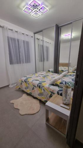 une chambre avec un lit et un miroir dans l'établissement Bel Appartement F3 proche de la plage, à Pietrosella