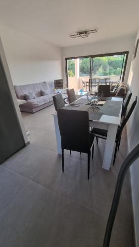 une salle à manger et un salon avec une table et des chaises dans l'établissement Bel Appartement F3 proche de la plage, à Pietrosella