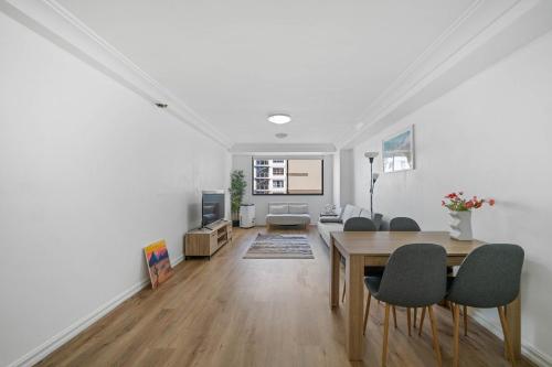a white living room with a table and chairs at Spacious 2BR Apt & DarlingHarbour&Chinatown-2 mins walk in Sydney