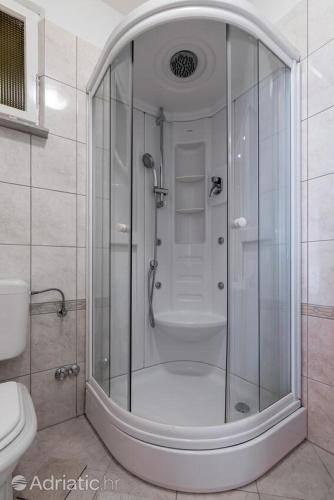 a shower with a glass door in a bathroom at Studio apartman Bella in Selca
