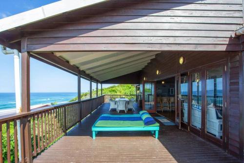 a porch with a bench on a deck with the ocean at Mar Azul 6 in Ponta Malongane