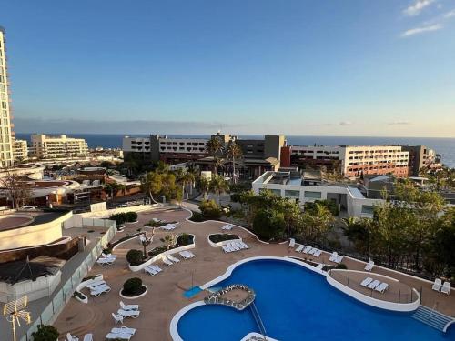 een uitzicht op een resort met een zwembad en stoelen bij Playa Paraiso Apartment in Adeje